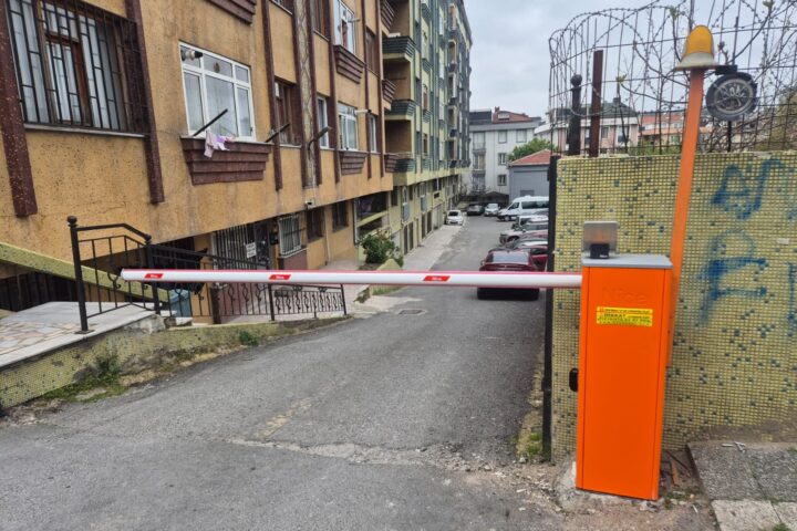 Dar sokak araç girişine kurulmuş kollu bariyer ve ikaz lambalı direk