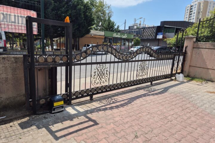 Desenli ferforje yana kayar bahçe kapısı ve kaidesine monte edilmiş motor ile ikaz lambası