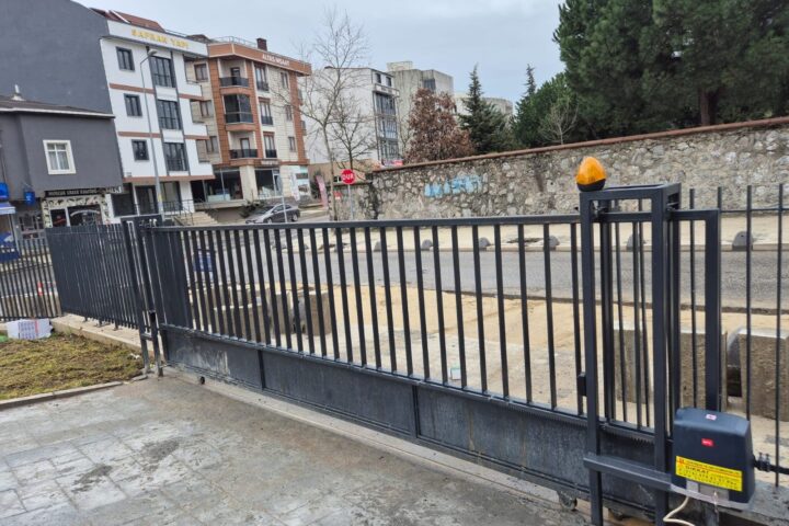 Site araç girişine kurulmuş yana kayar bahçe kapısı, ikaz lambası ve motor ünitesi